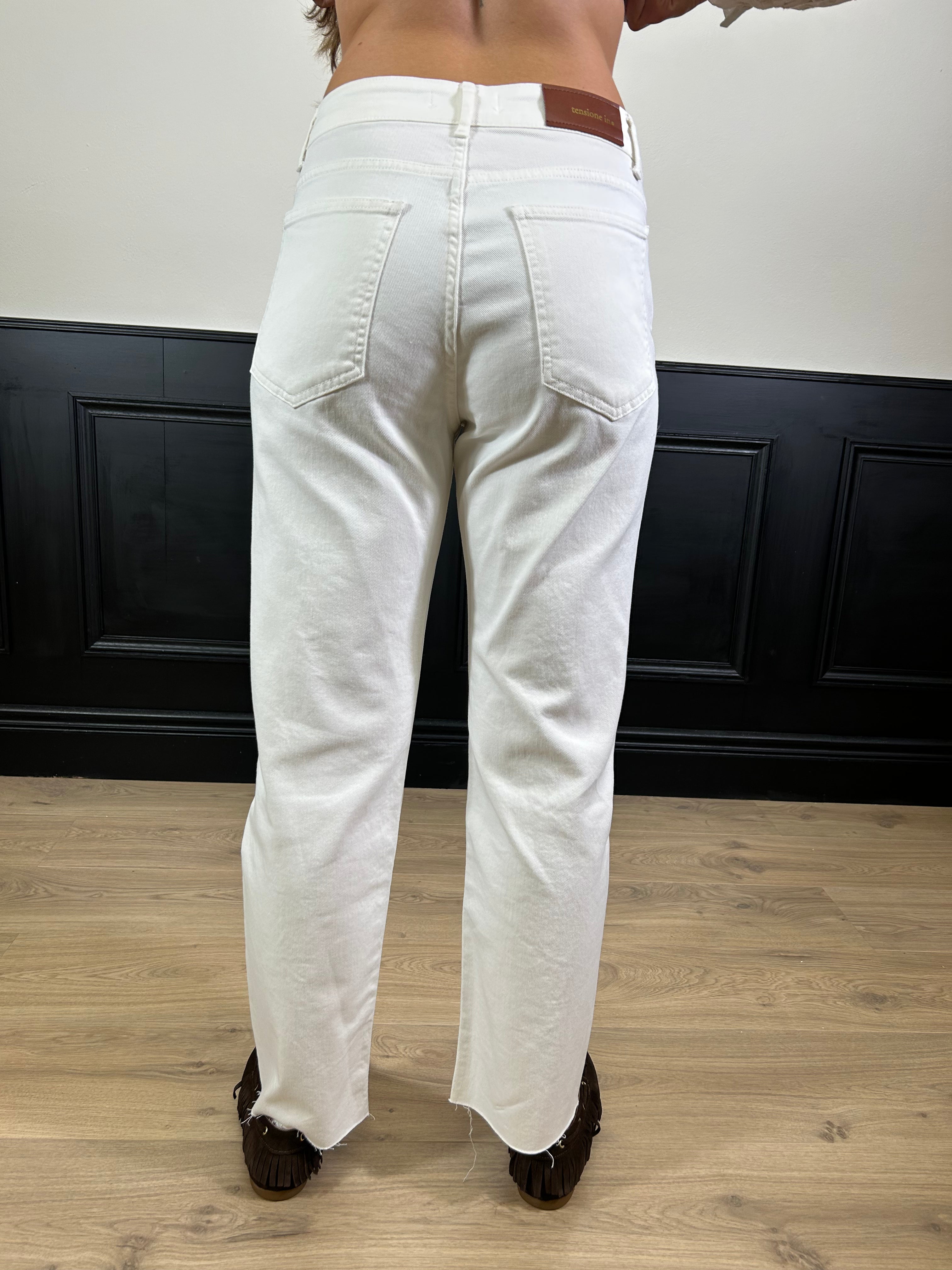 Jeans dritto sfrangiato sul fondo bianco