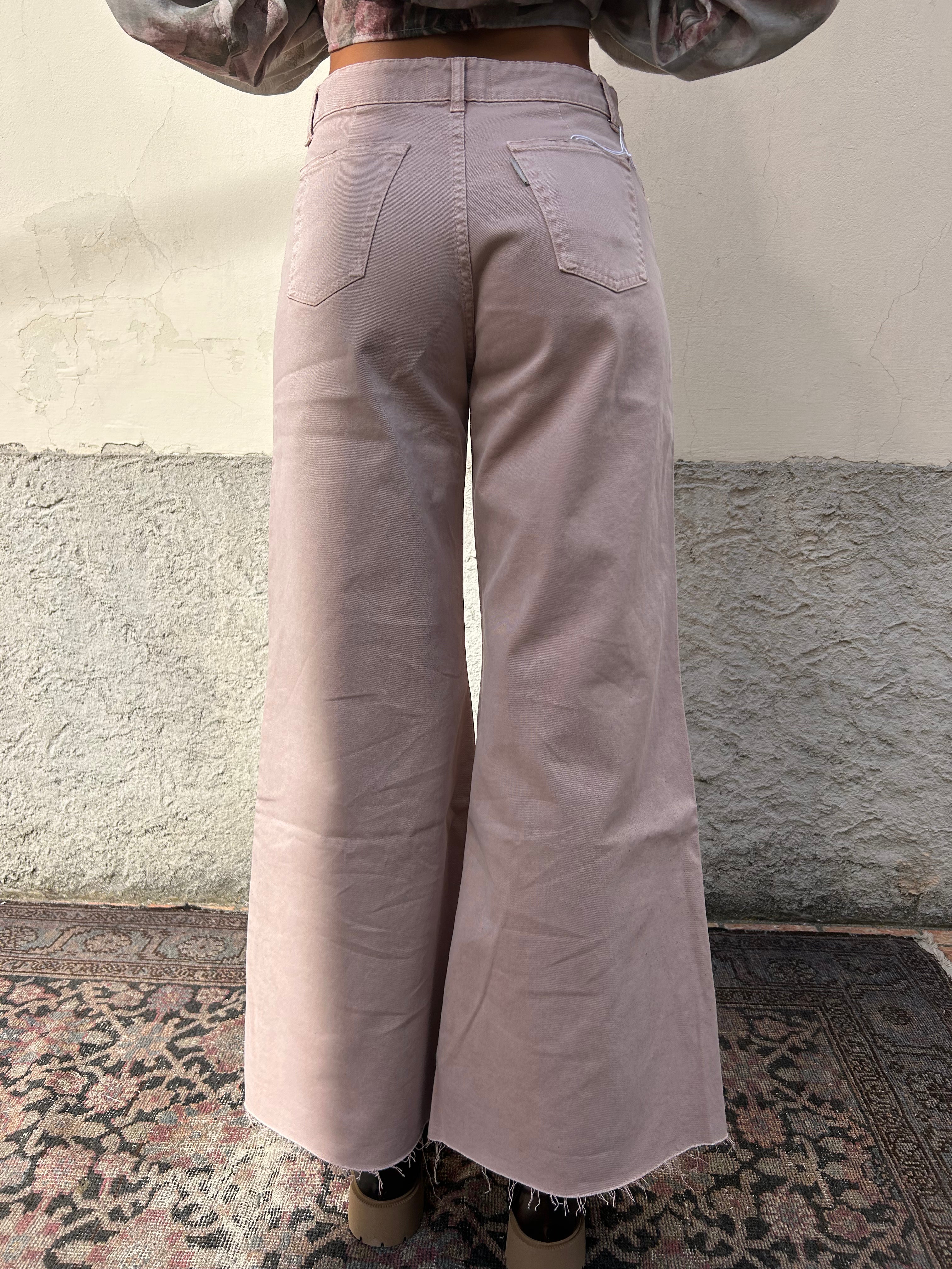 Jeans rosa sfrangiato sul fondo